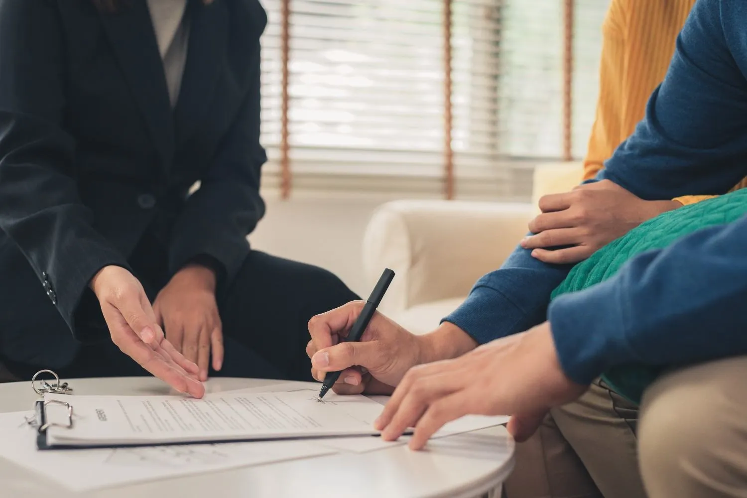 Insurance paperwork being signed at a low table